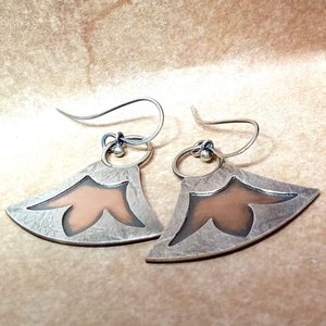 Mixed metal, bronze and argentium silver earrings with lotus design. Displayed flat on neutral background.