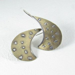 A pair of silver and bronze earrings with sterling silver embellishments. The earrings have a swooping curved shape and a modern, abstract design.