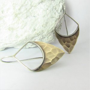 Striking, handcrafted sterling silver and bronze earrings have a two tone geometric design. Hammered for a knapped arrowhead appearance , oxidized and polished. Designed with a sterling silver fixed ear wire which holds them close to flatter your face. 1-5/8" (4.12cm) tall and 7/8" (2.2cm) wide.  Displayed against white stone and background.