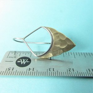 Striking, handcrafted sterling silver and bronze earrings have a two tone geometric design. Hammered for a knapped arrowhead appearance , oxidized and polished. Sterling silver ear wires, 1-5/8" tall and 7/8"wide.  Displayed on ruler against blue background.