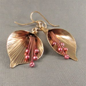 Handcrafted, unique mixed metal lily flower earrings are lovely with the warm metals of gold, bronze and copper. Reddened copper stamens tinkle gently. Ear wires are gold fill.2 and 1/8 long x .75 inch wide at widest point.