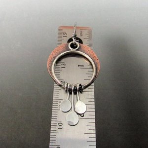 Copper and silver crescent moon dangle earrings with a circle design and three silver discs hanging from the bottom. The earrings are measured against a ruler, showing they are about 2 inch long.