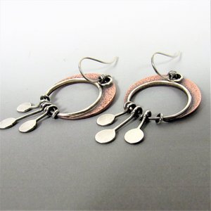 Copper crescent moon earrings with three argentium sterling silver paddles hanging beneath. Lightweight and easy to wear. apx. 2" long and 1" wide. Displayed on grey background.