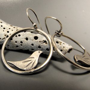 Swingy little bird earrings perfect for your favorite bird lover. Sweet details on the little bird that sits inside the swinging loop. Solid argentium sterling silver. Earrings measure 1.25 inch tall x 1" wide. Lightweight.