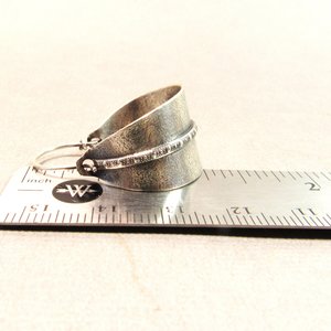Sterling silver hoop earrings basket style fancied up with a strip of patterned  silver wire against textured argentium silver. A perfect sterling silver hoop earring for every occasion!  Oxidized, polished, finished with sterling ear wires. 1.25" or 3.1cm tall,  7/8" or 2.22cm wide. Displayed on ruler.