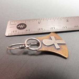 Mixed metal, bronze and silver ankh earrings. Body of earring shaped similar to the egyptian lotus motif with ankh on the front, suspended by silver ring and ear wires. 1.5" tall and 1" wide at widest point.  Displayed against ruler on grey background.