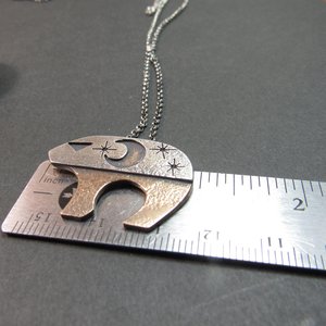 Ursa Major bear pendant against ruler to show size.