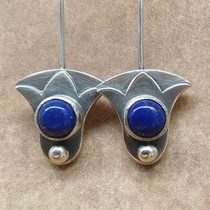 Argentium silver lotus earrings close up showing lapis lazuli cabochon and silver details.