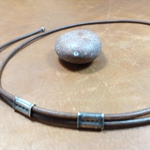 Sliding adjustable leather cord on mixed metal pendant.