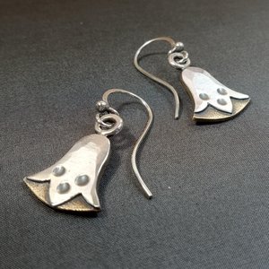 Front view mixed metal egyptian lotus earrings by Mocahete on dark background