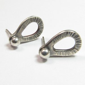 Sterling silver post back or stud earrings shaped like a raindrop and textured. A small orb of silver at the top is the crowning touch. Earrings measure 1/2" long and 1/4" wide. Comes with SS backs not pictured here.Displayed on light background.