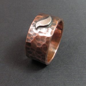 Hammered copper wide band ring with SS bird, photo on dark background.