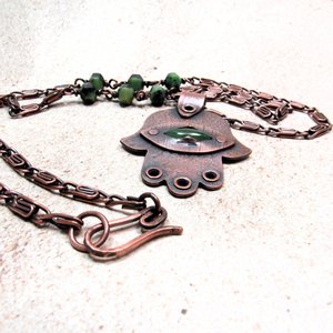 Handcrafted copper, jade and chrysoprase hamsa pendant necklace. 2" tall x 1.5" wide, 24.5" copper scroll chain with 3 faceted chrysoprase beads on each side. All riveted design. Up close of necklace hook closure. Displayed on neutral background.