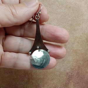 Mixed metal, copper and argentium SS Eiffel tower earrings displayed in hand.