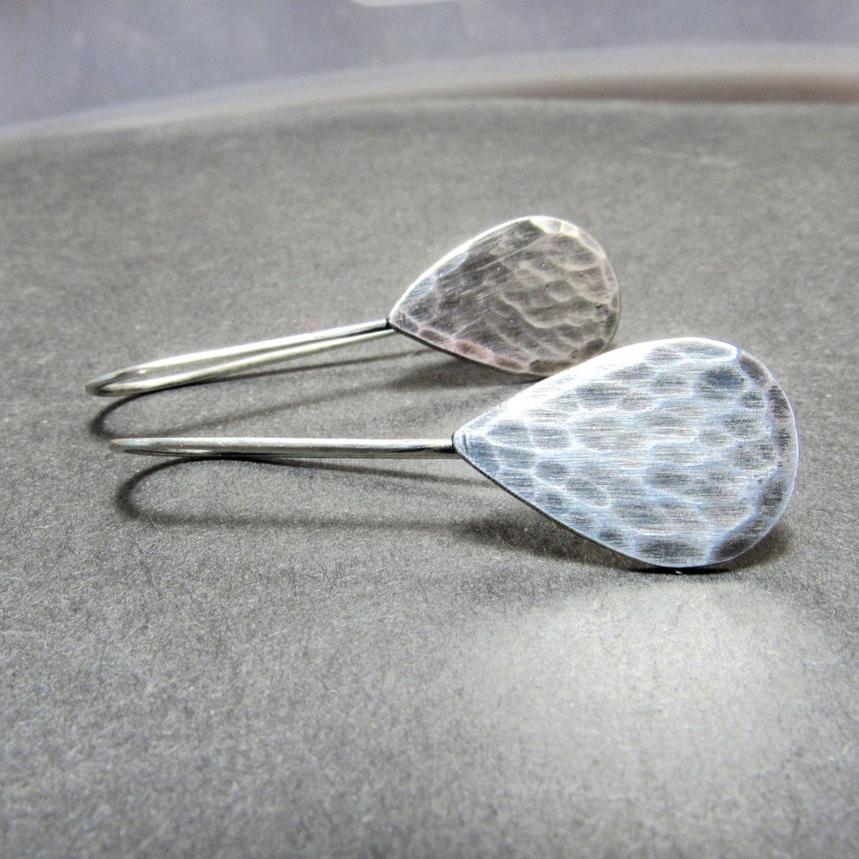 Classic hammered sterling silver teardrop earrings, 1.5" long. Displayed on grey background.