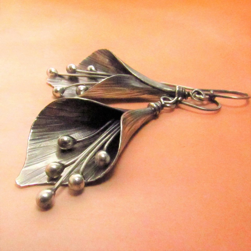 Argentium sterling silver lily earrings are quite an exotic statement as they sway gently. A pair of flower earrings that will never wilt. Oxidized and polished.2.5 inch long x  1 wide. Complete with a sweet tinkling sound!