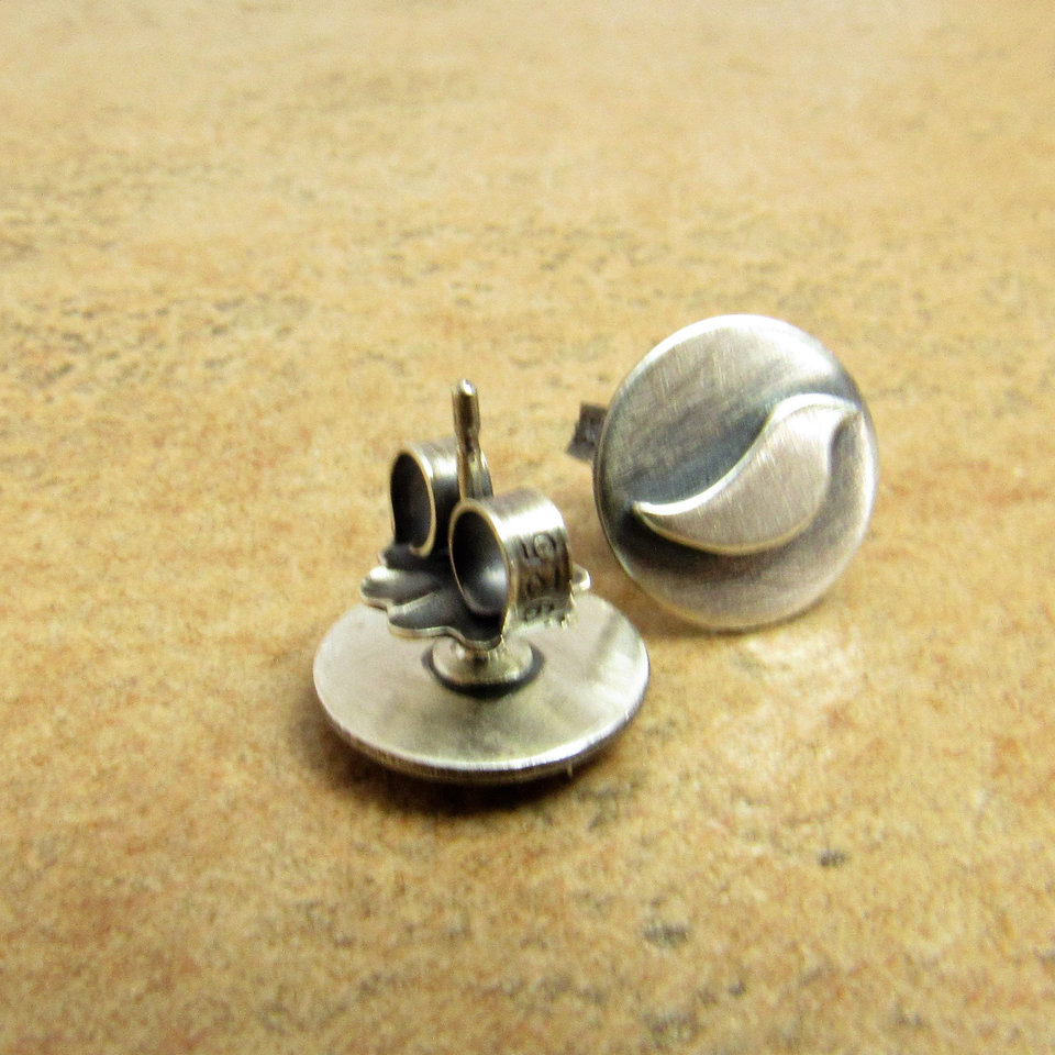 Pair of silver stud earrings with a bird design. The earrings are round and have a smooth, brushed finish. Photo shows clutch back.