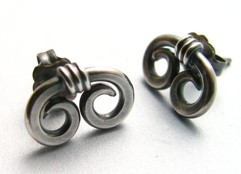 A pair of silver earrings with a spiral design. The earrings are made of sterling silver and have a post back.