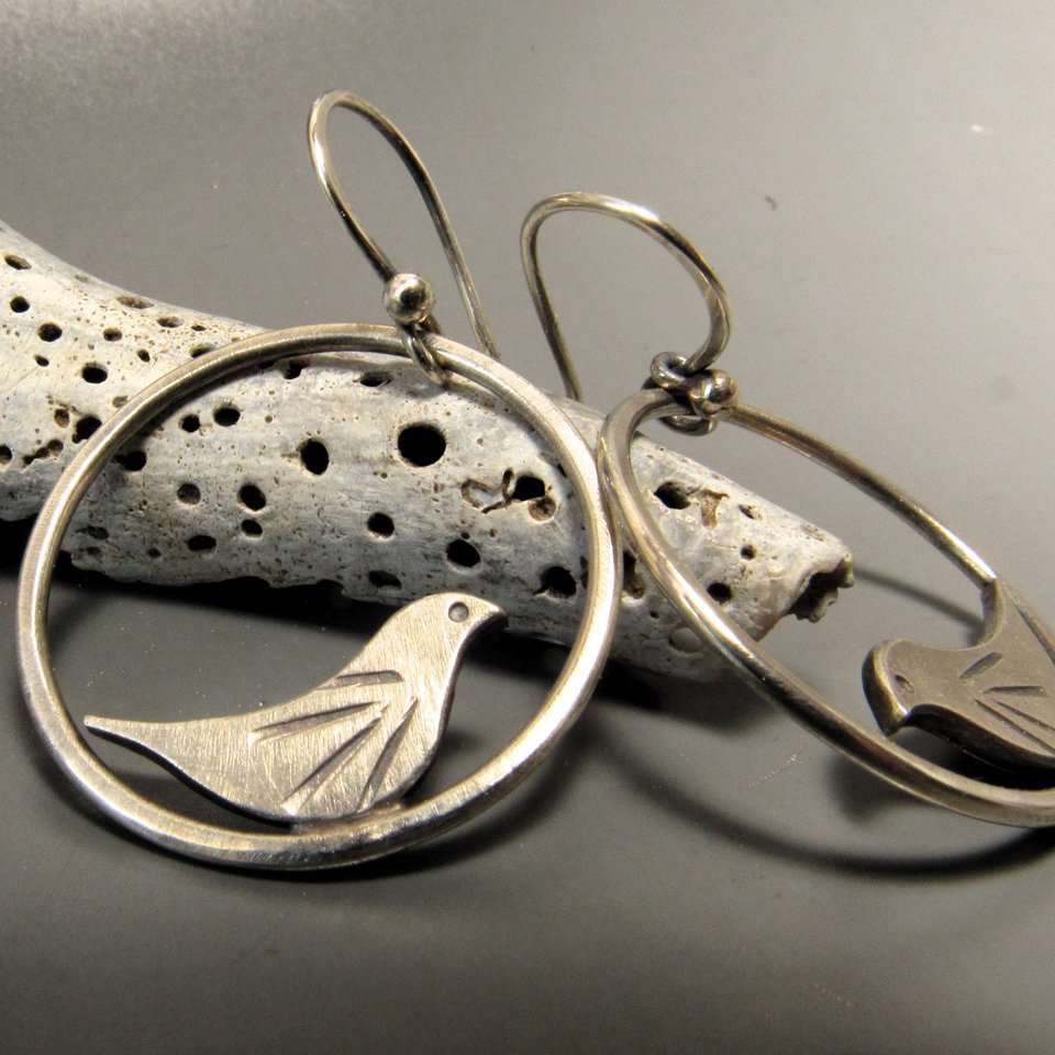 Swingy little bird earrings perfect for your favorite bird lover. Sweet details on the little bird that sits inside the swinging loop. Solid argentium sterling silver. Earrings measure 1.25 inch tall x 1" wide. Lightweight.