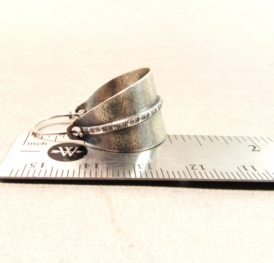 Sterling silver hoop earrings basket style fancied up with a strip of patterned  silver wire against textured argentium silver. A perfect sterling silver hoop earring for every occasion!  Oxidized, polished, finished with sterling ear wires. 1.25" or 3.1cm tall,  7/8" or 2.22cm wide. Displayed on ruler.