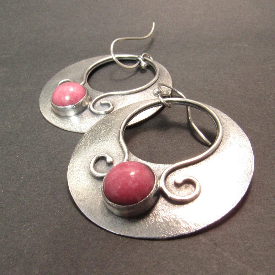 Lovely, large argentium sterling silver earrings in a gypsy style hoop dangle with earthy pink rhodonite cabochons. Swirling ss wire embellishments. Hoops are 1.75" tall x 1.5 inch wide. Statement earrings, oxidized for depth and drama.