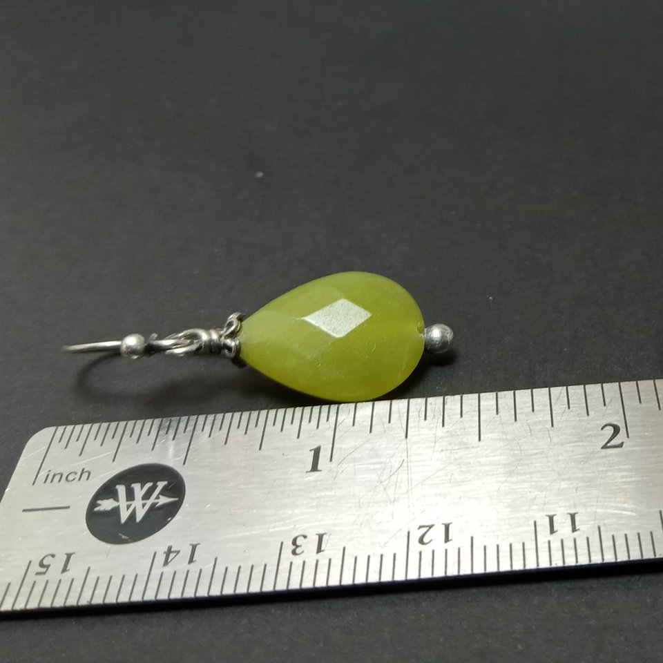 Serpentine and silver dangle earrings against ruler to show size.