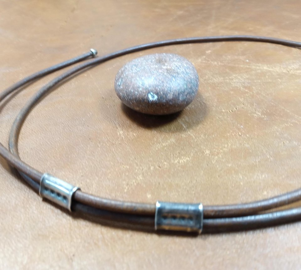 Sliding adjustable leather cord on mixed metal pendant.