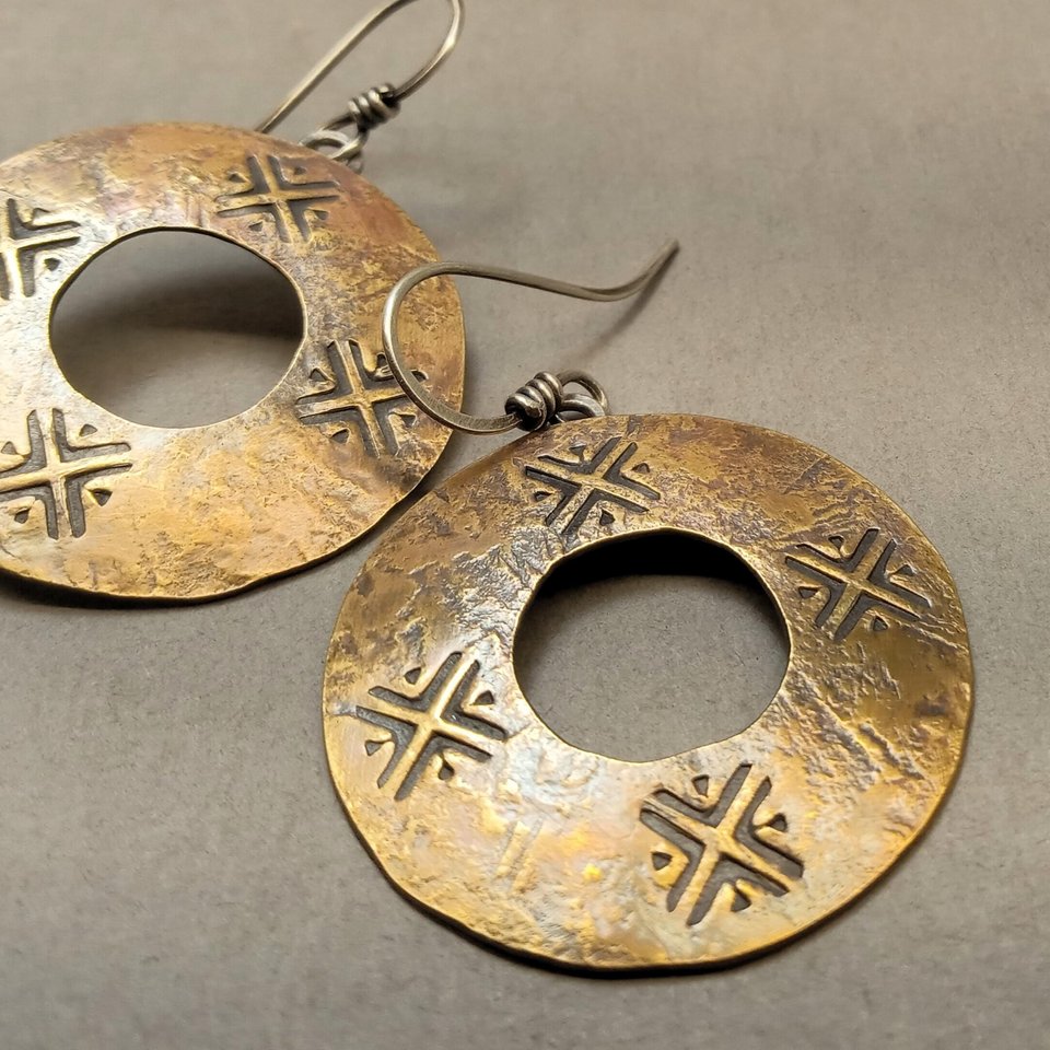 Front view of bronze earrings with center cutout and Argentium ear wires on neutral background
