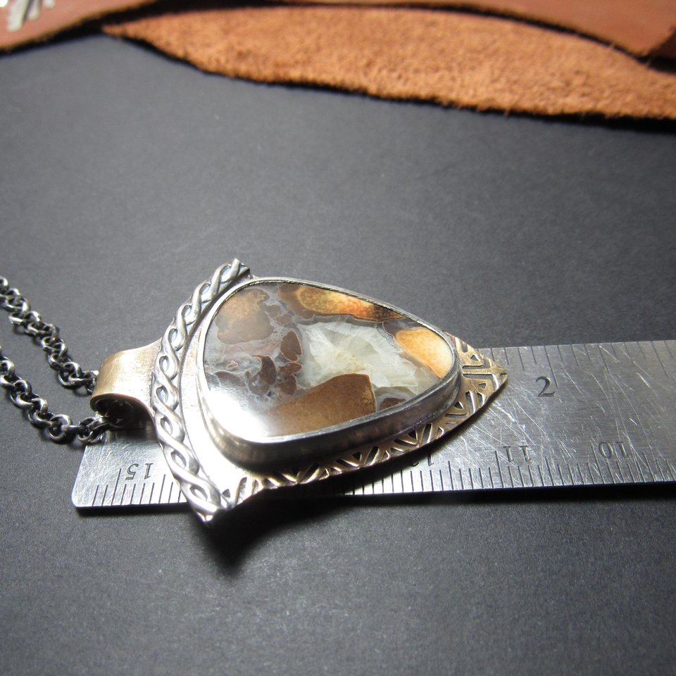 Photo of mixed metal, cobra jasper pendant against ruler to show size.