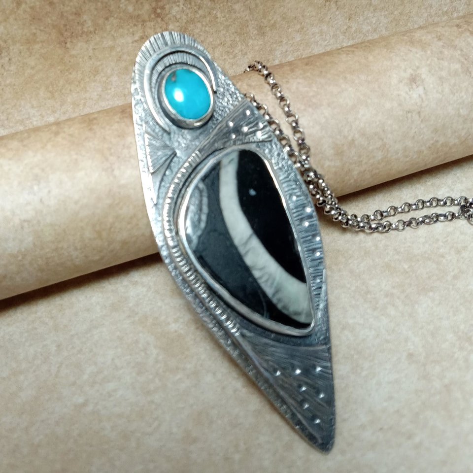 one of a kind colus fossil and turquoise pendant necklace on neutral background