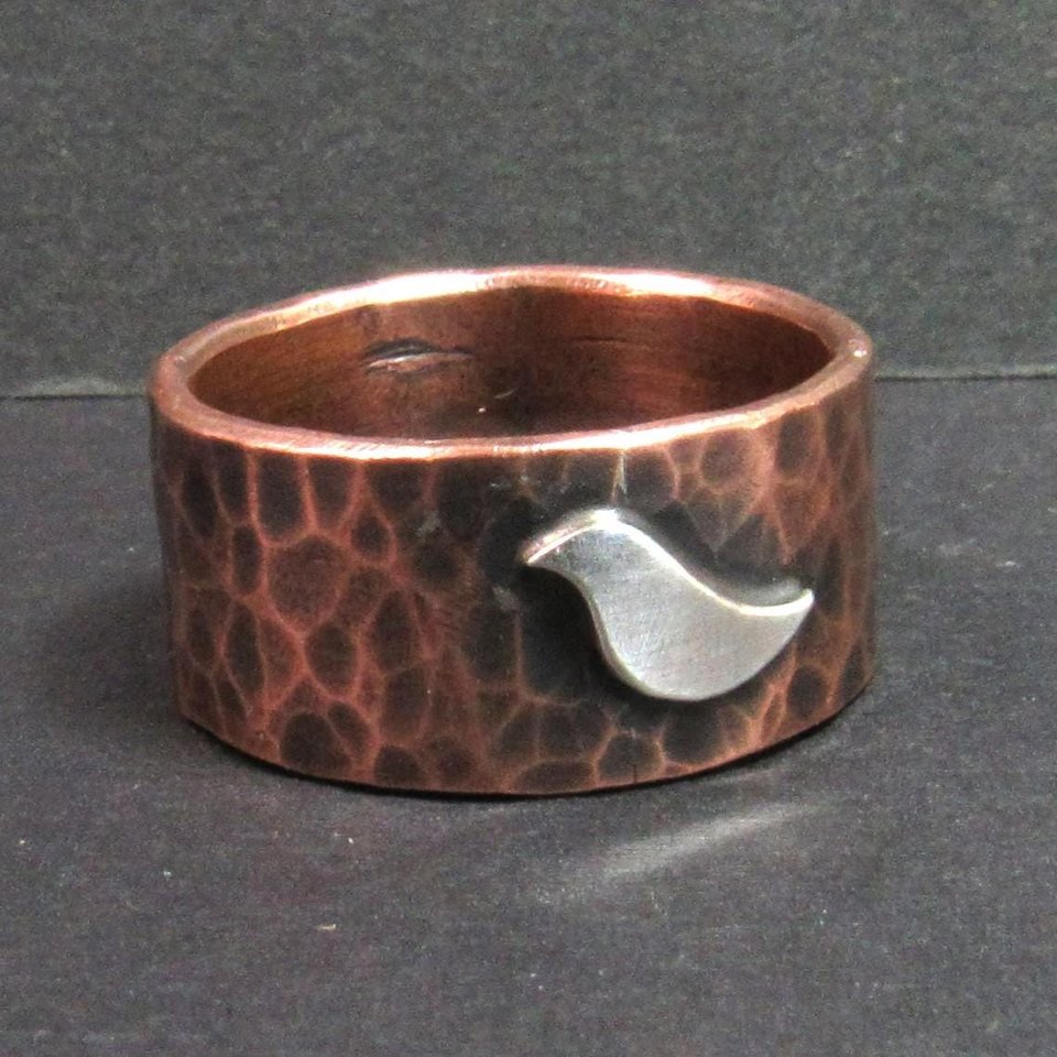 Handcrafted copper ring with sterling silver bird for men, women, unisex. Photo on dark background