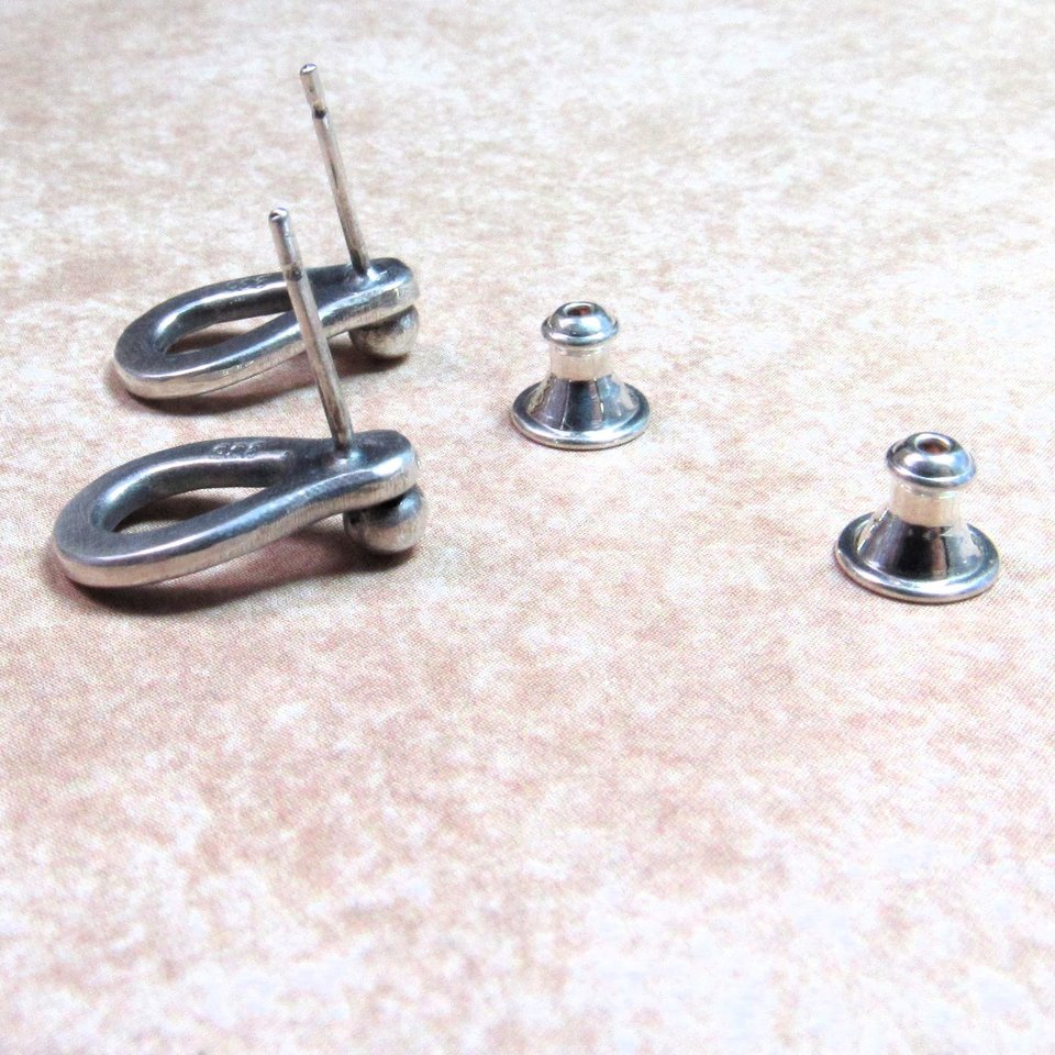 Reverse side of sterling silver post back or stud earrings shaped like a raindrop and textured. A small orb of silver at the top is the crowning touch. Earrings measure 1/2" long and 1/4" wide. Comes with SS backs.Displayed on light background.