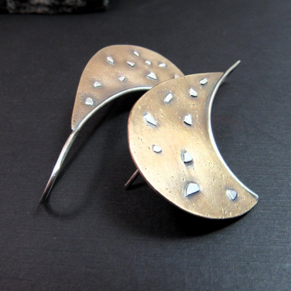 Avant Garde Bronze and Sterling silver earrings on black background