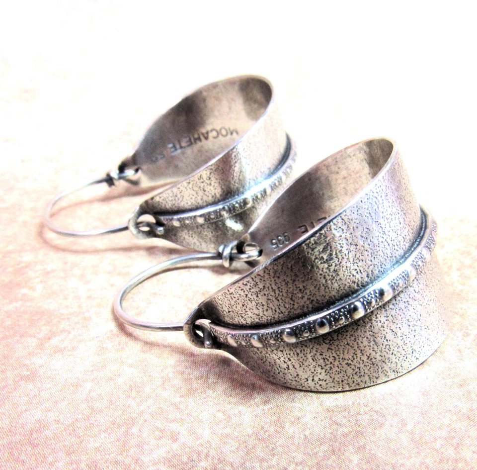 Sterling silver hoop earrings basket style fancied up with a strip of patterned  silver wire against textured argentium silver. A perfect sterling silver hoop earring for every occasion!  Oxidized, polished, finished with sterling ear wires. 1.25" or 3.1cm tall,  7/8" or 2.22cm wide. Displayed on neutral background.