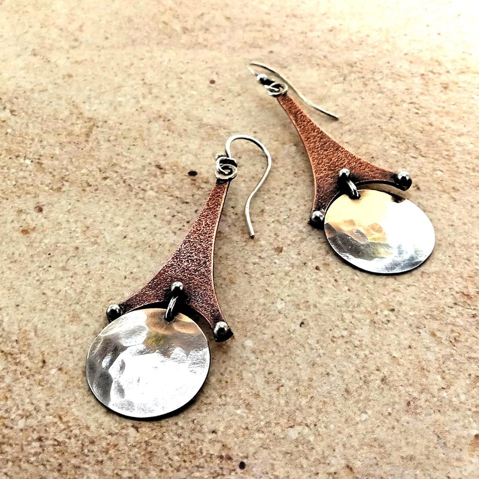 Copper and argentium SS Eiffel tower earrings, 2.5" long x .75" wide. Displayed on sand color background.
