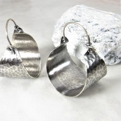 Rustically classic elegance in a pair of handcrafted hammered and oxidized sterling silver basket hoop earrings. The hammered surface catches the light beautifully. So very versatile with their soulful boho energy. 1 and 3/8 inch tall x 1 inch wide