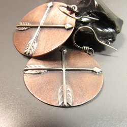 Large mixed metal disc shaped crossed arrow earrings in copper and sterling silver. !.75 inch tall x 1.25 inch wide, lightweight at only 5 grams per earring